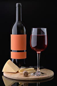 Alkoholfri vin på skærebræt med ost