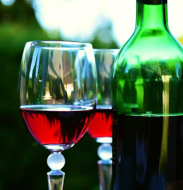 Rødvin i rødvinsglas med flaske ved siden af
